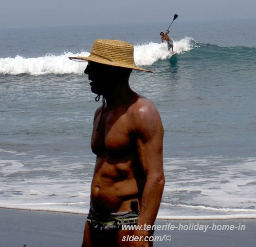 Health in Tenerife obviously on a man's mind who protects his head in the sun on a beach.