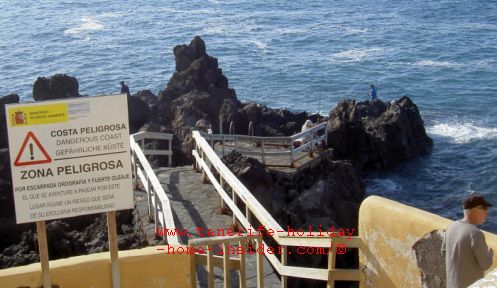 Rogue wave warning danger sign on Punta Brava idyllic spot for fishing